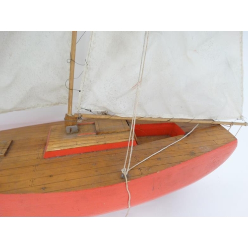 381 - Toy: A Bermuda rigged pond yacht with fabric sale and red painted wooden hull. 41'' high.   Please N... 