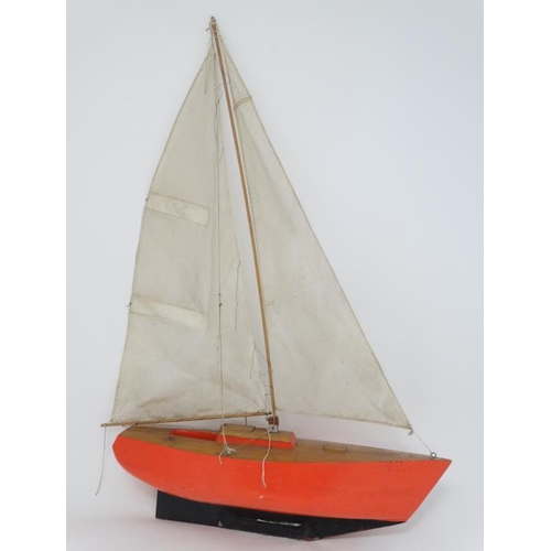 381 - Toy: A Bermuda rigged pond yacht with fabric sale and red painted wooden hull. 41'' high.   Please N... 