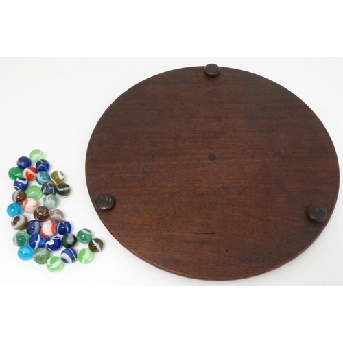 385 - Toy: A 19thC mahogany solitaire board with 32 coloured handmade marbles.  Please Note -  we do not m... 