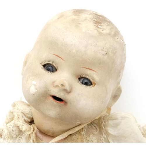 387 - Toy: A German Bisque Childs doll, having blue glass painted eyes , painted features and hinged limbs... 