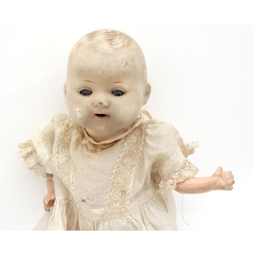 387 - Toy: A German Bisque Childs doll, having blue glass painted eyes , painted features and hinged limbs... 