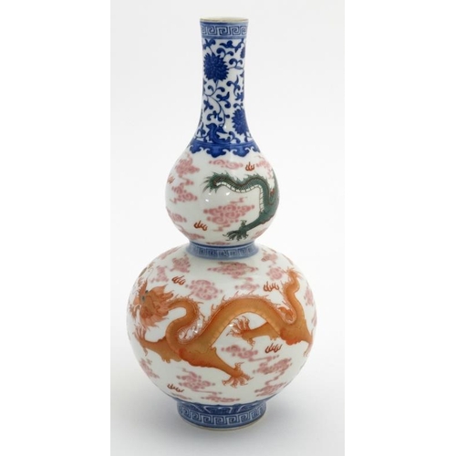 403 - A Chinese double gourd vase decorated with 5 clawed dragons amidst scrolling cloud, fighting over a ... 