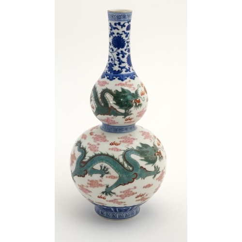 403 - A Chinese double gourd vase decorated with 5 clawed dragons amidst scrolling cloud, fighting over a ... 