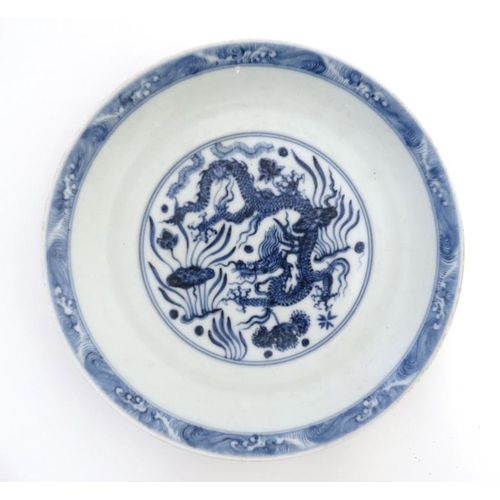 411 - A blue and white Chinese dish decorated with 5 clawed dragon amongst weed to central well and exteri... 