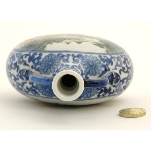 414 - A small blue and white Chinese twin handled moon flask, painted in blue with lotus scrolls and the t... 