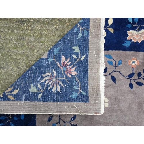 81 - Rug / Carpet : A Chinese woollen carpet with floral decoration,  blue banded border and mushroom cen... 