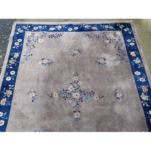 81 - Rug / Carpet : A Chinese woollen carpet with floral decoration,  blue banded border and mushroom cen... 