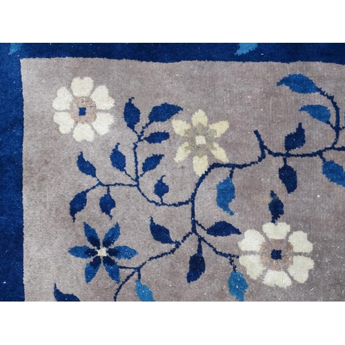 81 - Rug / Carpet : A Chinese woollen carpet with floral decoration,  blue banded border and mushroom cen... 