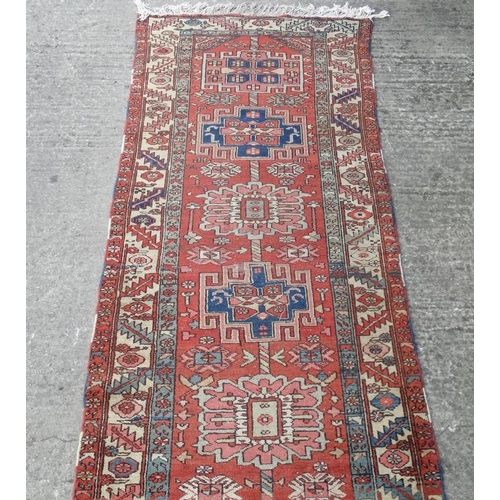 86 - Carpet / Rug : A hand made early- mid 20 thC Persian long Runner Rug having a red ground , blue crea... 