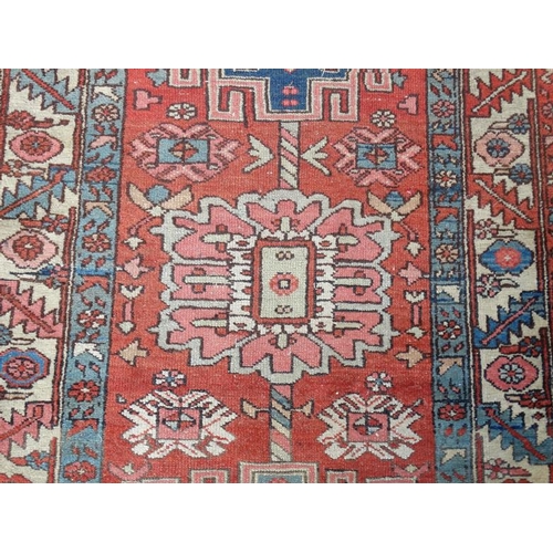 86 - Carpet / Rug : A hand made early- mid 20 thC Persian long Runner Rug having a red ground , blue crea... 