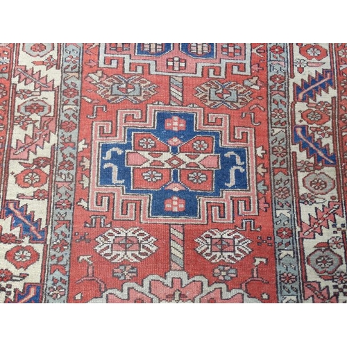 86 - Carpet / Rug : A hand made early- mid 20 thC Persian long Runner Rug having a red ground , blue crea... 