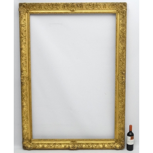 211 - Gilt frame : a large ornate XIX gilded gesso and wood frame having internal measurements  55 1/4 x 3... 