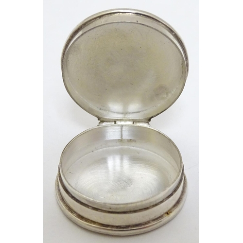 134 - A Contemporary .925 silver pill box of circular form with enamel decoration to the hinged lid depict... 