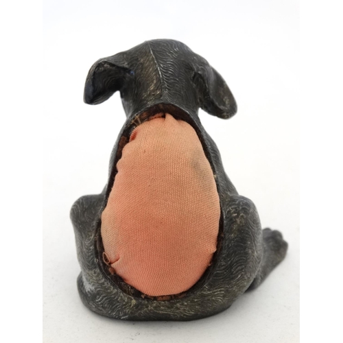 135 - An early 20thC novelty cast metal pin cushion formed as a seated puppy dog with glass eyes. Approx 2... 