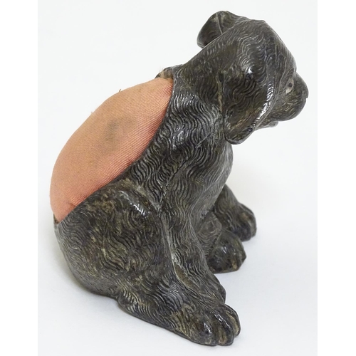 135 - An early 20thC novelty cast metal pin cushion formed as a seated puppy dog with glass eyes. Approx 2... 