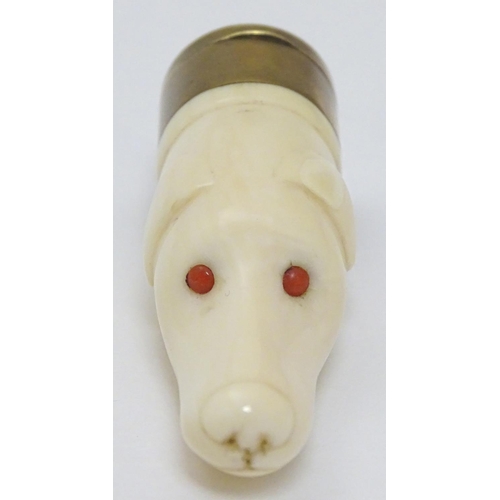 146 - A Victorian novelty vinaigrette formed as a carved ivory dogs head with red eyes and having brass vi... 