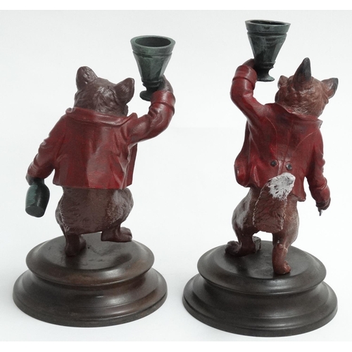 150 - A pair of 21st C cold painted bronze novelty figurine/ candlestick holders on socles, formed as a be... 