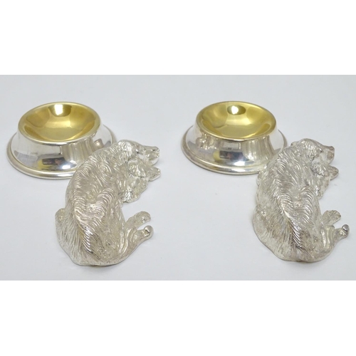 157 - A pair of Novelty silver plate salts formed as recumbent dogs before bowls. Approx 4 1/2''