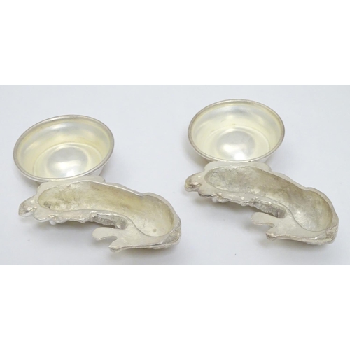 157 - A pair of Novelty silver plate salts formed as recumbent dogs before bowls. Approx 4 1/2''