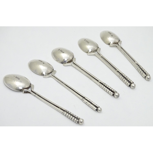 182 - A matched set of 5 silver teaspoons, the handles formed as pair of golf clubs surmounted by a golf b... 