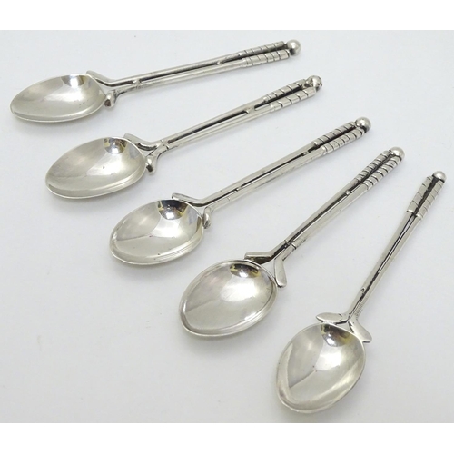 182 - A matched set of 5 silver teaspoons, the handles formed as pair of golf clubs surmounted by a golf b... 