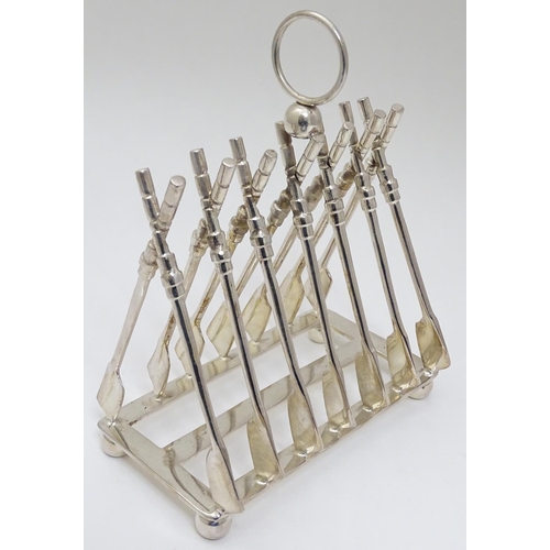 190 - Rowing: A novelty 6-slice silver plated toast rack, the bars formed as oars. 21stC  Approx 8'' high ... 