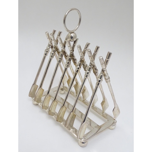 190 - Rowing: A novelty 6-slice silver plated toast rack, the bars formed as oars. 21stC  Approx 8'' high ... 