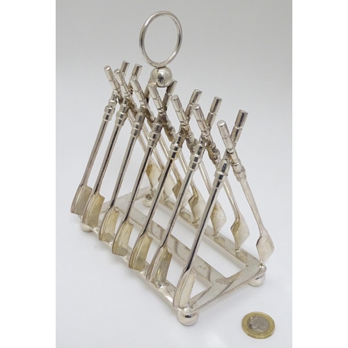 190 - Rowing: A novelty 6-slice silver plated toast rack, the bars formed as oars. 21stC  Approx 8'' high ... 