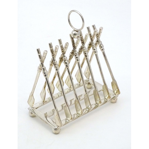 190 - Rowing: A novelty 6-slice silver plated toast rack, the bars formed as oars. 21stC  Approx 8'' high ... 