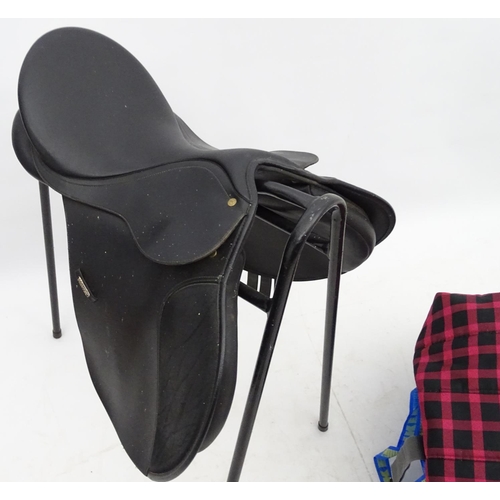 316 - Equine Interest : A black saddle by Wintec together with a saddle rack and various horse rugs/ blank... 