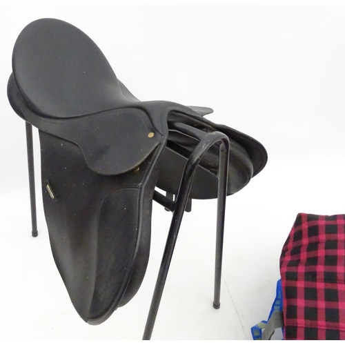 316 - Equine Interest : A black saddle by Wintec together with a saddle rack and various horse rugs/ blank... 