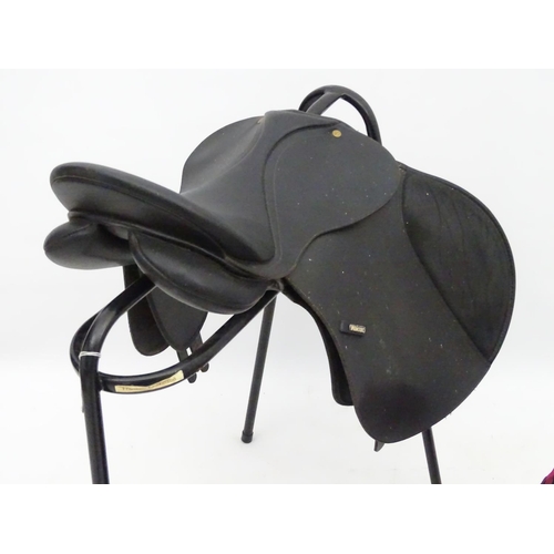 316 - Equine Interest : A black saddle by Wintec together with a saddle rack and various horse rugs/ blank... 