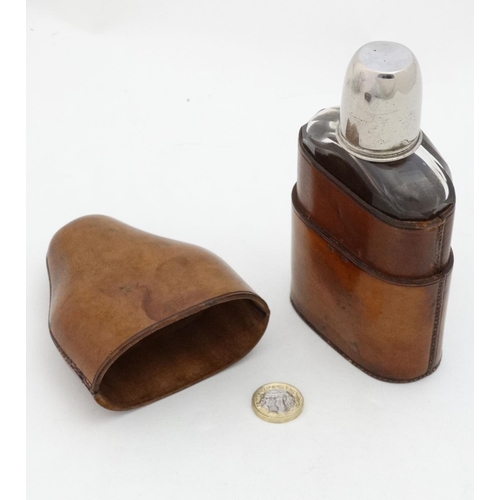 343 - Field Sports : An early 20thC glass flask with silver plate tot cup to top within a brown leather ca... 