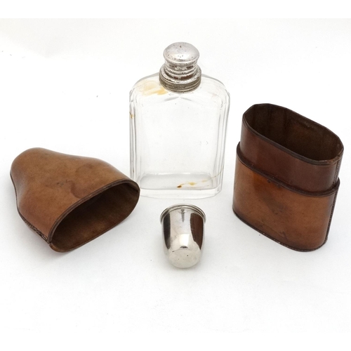 343 - Field Sports : An early 20thC glass flask with silver plate tot cup to top within a brown leather ca... 