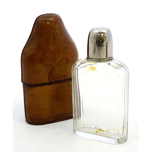 343 - Field Sports : An early 20thC glass flask with silver plate tot cup to top within a brown leather ca... 