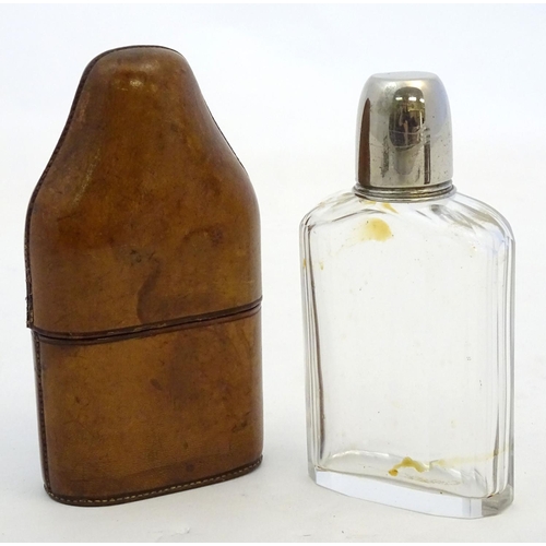 343 - Field Sports : An early 20thC glass flask with silver plate tot cup to top within a brown leather ca... 