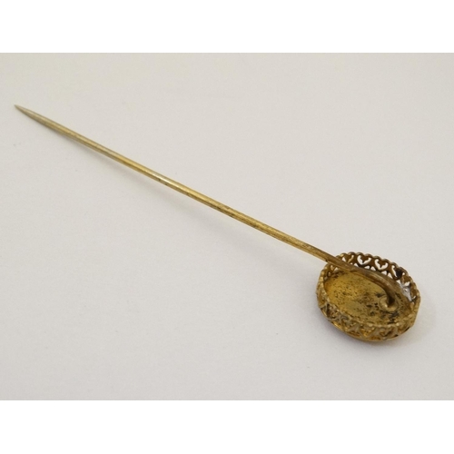 421 - A gilt metal stick pin surmounted by a circular image of a squirrel. The whole 3'' high