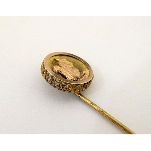 421 - A gilt metal stick pin surmounted by a circular image of a squirrel. The whole 3'' high