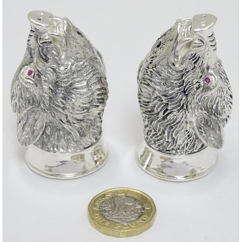 430 - A novelty white metal salt and pepper cruet formed as board heads with red stone eyes. marked .800. ... 