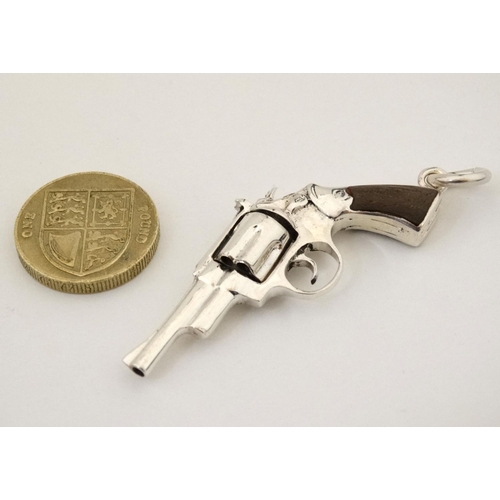 454 - A pendant formed as a hand gun / revolver. 21stC .  2 1/4'' long