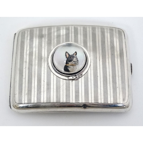 466 - A silver cigarette case hallmarked Birmingham 1921 with later applied Essex Crystal Cabochon depicti... 