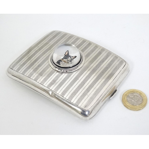 466 - A silver cigarette case hallmarked Birmingham 1921 with later applied Essex Crystal Cabochon depicti... 