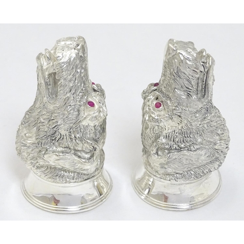 471 - A novelty white metal salt and pepper cruet formed as dog heads set with red stone eyes. marked .800... 