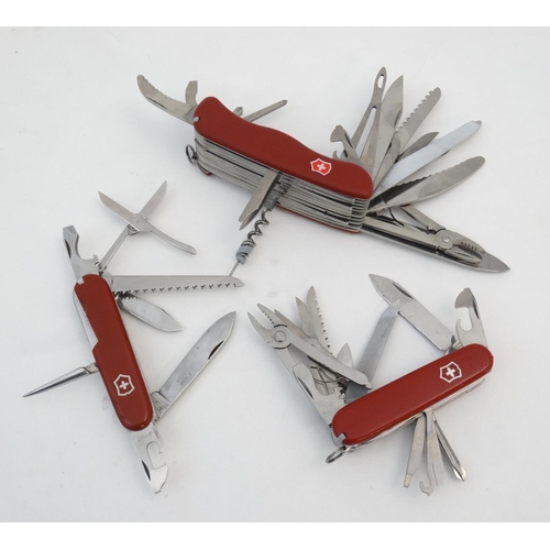 545 - A collection of three Victorinox Swiss army knives, each having a range of blades and tools, the lar... 