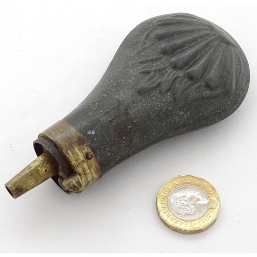 587 - Shooting: A 19thC pewter and brass pistol powder flask, having shell decoration and coil spring open... 