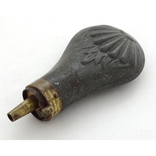 587 - Shooting: A 19thC pewter and brass pistol powder flask, having shell decoration and coil spring open... 