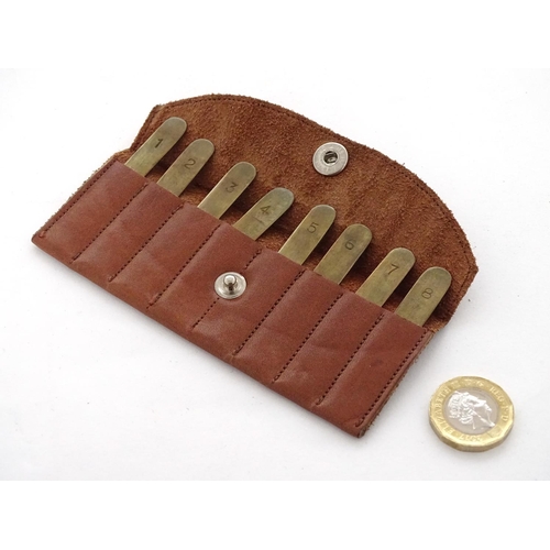 588 - Shooting: A set of 8 - peg brass position finders, in a tan leather case, the pegs 1 3/4'' long