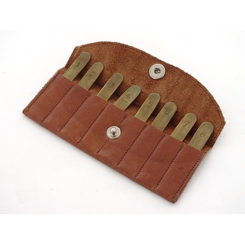 588 - Shooting: A set of 8 - peg brass position finders, in a tan leather case, the pegs 1 3/4'' long