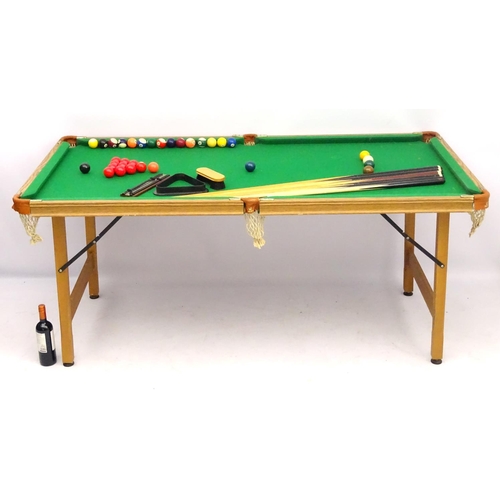 122 - A portable cue-sports table, with green baize top, together with six cues, a boxed set of snooker, p... 