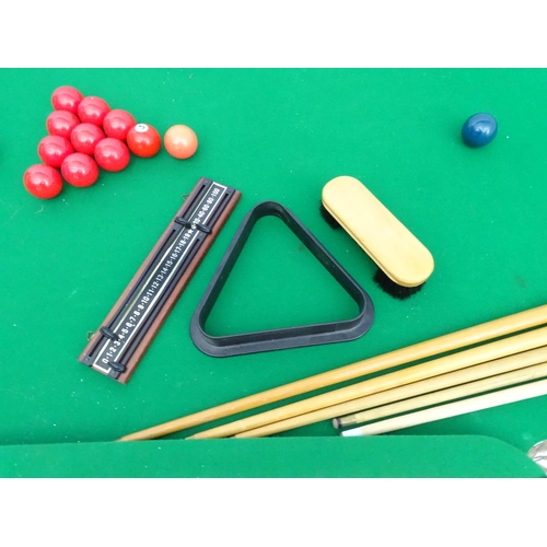 122 - A portable cue-sports table, with green baize top, together with six cues, a boxed set of snooker, p... 